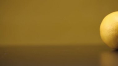 Sarı arka planda siyah bir masada limonlu rulo. Kapat..