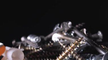 Masanın üzerinde bir avuç cıvata ve vida var. Kamera düzgün çalışıyor. Siyah arkaplan