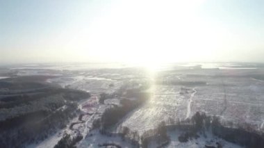 Kardaki orman, donmuş ağaçların ve tarlaların üzerinde uçuyor.