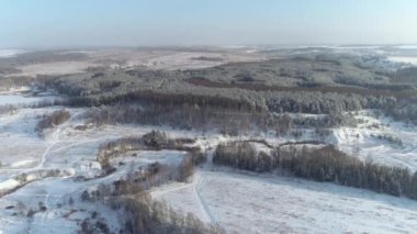 Karlı bir ormanda mavi bir gölün üzerinde uçmak. Kış. Karda mavi su olan göl