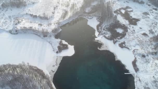 雪の森の中の青い湖を飛んでいる 雪の中の青い水の湖 — ストック動画