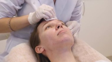 Doktor hastanın yüzünü estetik ameliyatlara hazırlar.