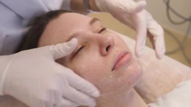 Doktor hastanın yüzünü estetik ameliyatlara hazırlar.