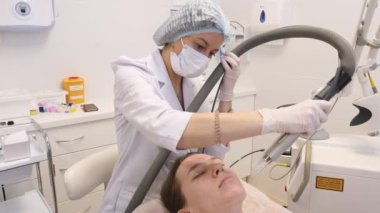 Doktor hastanın yüzünü kısmi bir lazerle temizliyor. Güzellik tedavileri.