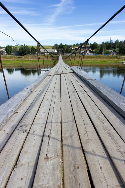 Paisagem rural no verão com ponte suspensa de madeira — Fotografia de Stock