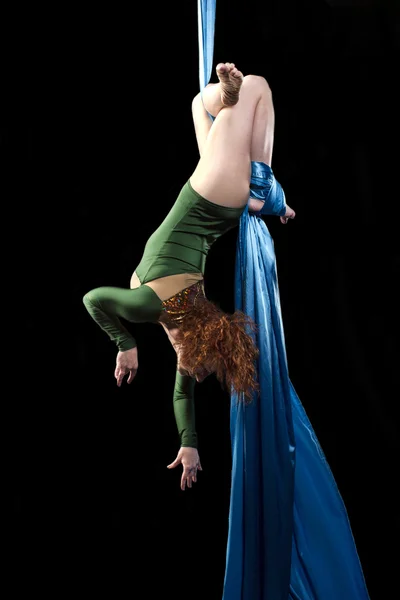 Молодая женщина делает упражнения на воздушный шелк — стоковое фото