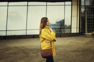 Yüksek katlı binalar artalanları sandalyesinde güzel genç kadın