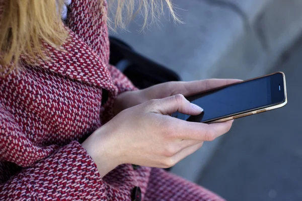 Hands of young woman closeup with mobile phone chatting with friend