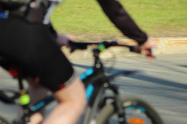 Bir bisiklet yakın çekim yaz aylarında bir adam sürmek. Yumuşak ve anlayışı bulanıklık