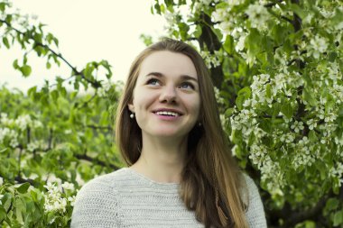 Güzel genç kız portresi yakın çekim yeşil yaprakları açık havada bir çiçek açması ağaç arasında