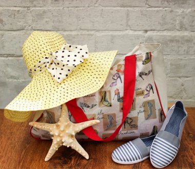 Yolculuk için hazırlanıyor. Hasır şapka, plaj çantası ve terlik, ahşap zemin üzerinde deniz kabuğu yıldız yakın çekim