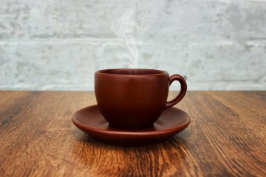 Bir uçan daire ve aromatik ahşap masa yakın çekim duman ile kahverengi kahve fincanı