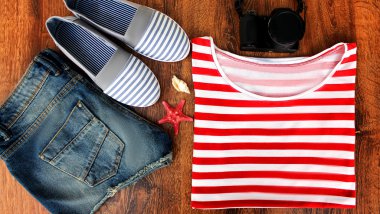 Ayarla denize gitmek için elbise: kot şort, çizgili bir gömlek ve spor ayakkabı, photocamera, kabukları, top ahşap arka plan görünümünü