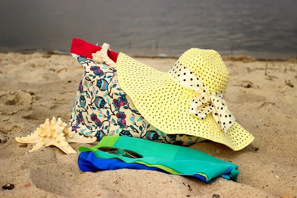 Stro hoed, strand tassen, sarong, bril, starfish close-up liggend op de achtergrond van de zee — Stockfoto