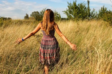 Genç güzel kız aracılığıyla yüksek kuru çim alan ve ishal elinde yaz aylarında yürüyüş.