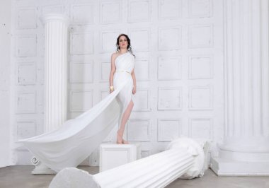 Güzel Yunan tanrıçası kadın beyaz antik harabelerin arasında. Yunan stili kadın.