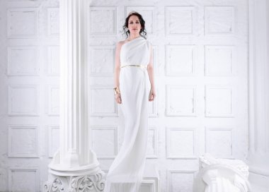 Güzel Yunan tanrıçası kadın beyaz antik harabelerin arasında. Yunan stili kadın.