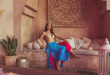 Dans kostümlü güzel bayan doğu mimarisinin arka planına yakın çekim yapıyor. Mata Hari kostüm.