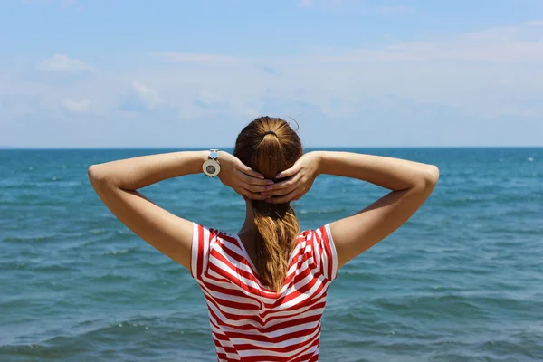 Chica joven mira el mar azul —  Fotos de Stock