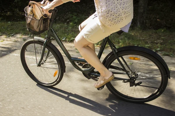 Rida cykel på skogsvägen. Närbild av ung kvinna ridning cykel — Stockfoto