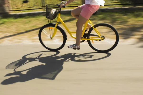 Bewegung verschwimmt, gelbes Fahrrad auf der Forststraße. Nahaufnahme einer jungen Frau auf dem Fahrrad — Stockfoto