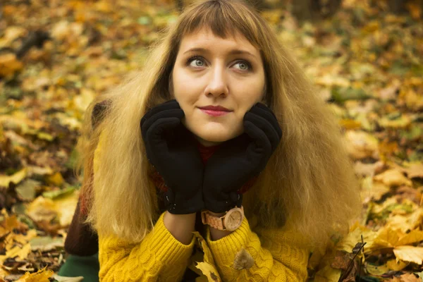 Young beautiful girl lying on autumn leaves — Stock Photo, Image