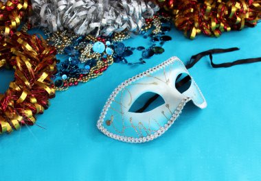 Blue carnival mask on a blue background with festive decorations clipart