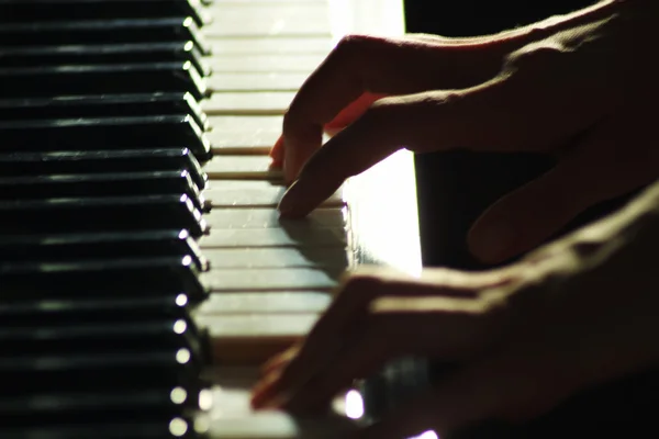 Fingrarna av ung kvinna som spelar på piano närbild. Mjuk och oskärpa befruktningen — Stockfoto