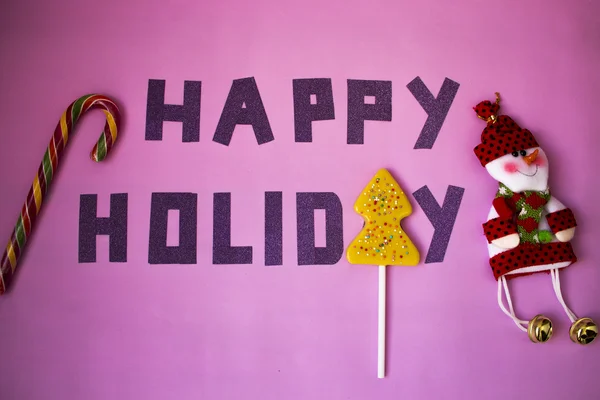 "节日快乐"雪人与糖果粉红的底色上孤立的假期的愿望 — 图库照片