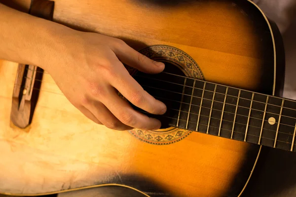 Ung kille spela på gitarr. Hand och gitarr närbild. Mjuk och oskärpa befruktningen — Stockfoto