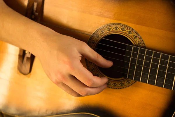 Ung kille spela på gitarr. Hand och gitarr närbild. Mjuk och oskärpa befruktningen — Stockfoto