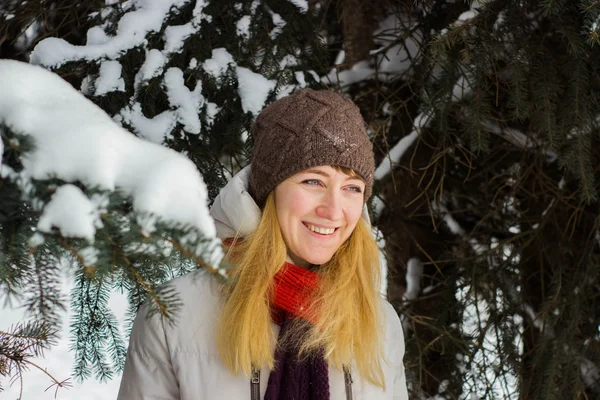 Joven hermosa mujer de pie detrás de los árboles en temporada de invierno — Foto de Stock