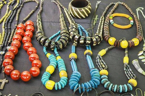 Afrikai hagyományos kézműves fényes színes gyöngyök karkötők, nyakláncok, medálok. — Stock Fotó