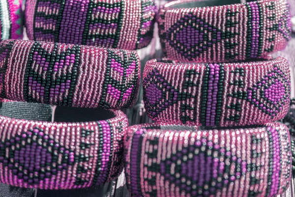 Afrikanische traditionelle handgefertigte Armbänder aus Perlen in violetten Lila-Farben. — Stockfoto