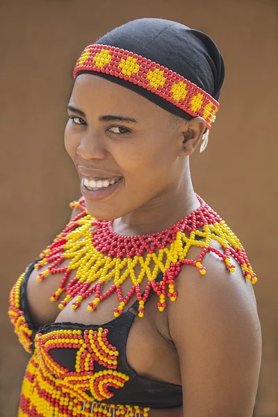 África do Sul, Gauteng, Lesedi Cultural Village (centro único da cultura africana) 04 Julho, 2015. Sorrindo jovem preto bela mulher Zulu em tradicional artesanal colorido escarlate amarelo contas roupas . — Fotografia de Stock