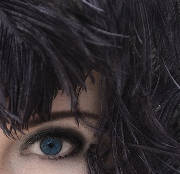 クローズ アップ黒い羽飾りの深い青い目を持つ神秘的な若い美しい女性の肖像画。ファッション撮影をモデル化。煙のような目のメイク。純粋な完璧な肌。ファム ・ ファタール。レトロなスタイル。ビンテージ スタイル. — ストック写真