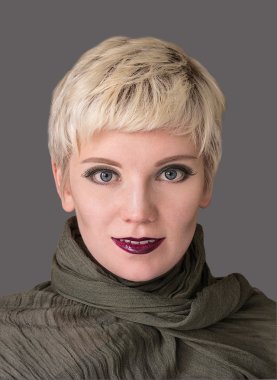 Beautiful woman blonde wearing khaki scarf on grey background. Close-up portrait. Model shot. Fashion  hairstyle with fringe, haircut and makeup in grey shades. Lilac lips. Modern highlighting. Elegant safari style. clipart