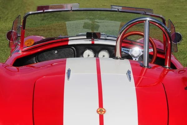 Red dashboard of old model sport car AC Cobra at the festival Highland Gathering. Vintage car style.