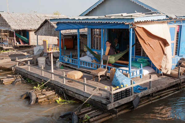 On the terrace of the house of the village on the water Tonle Sap Lake in Cambodia in a hammock relaxing family.