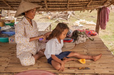 Anne penye kızı üzerinde bir tembel bir gölgelik altında