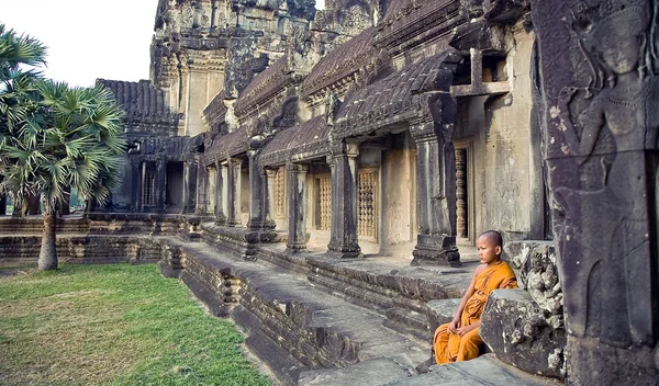 Temple yakınındaki kayalarda küçük keşiş oturur. Angkor kalıntıları küçük Budist Keşiş. Angkor Wat, tarihi karmaşık ana girişinde. 11/20/2009: Angkor için ana giriş