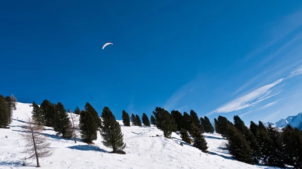 Paraşütçü dağ yamacı üzerinde gökyüzünde — Stok fotoğraf