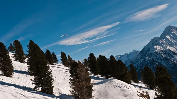 Bir arka plan Dağları'nın Gökteki paraşütçü — Stok fotoğraf
