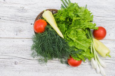 Domates, sarı biber, dereotu, maydanoz ve soğan bir sepet içinde 