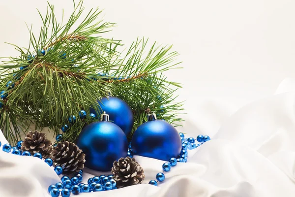 Çamın dalları ve çam kozalakları bir whit üzerinde mavi Noel topları