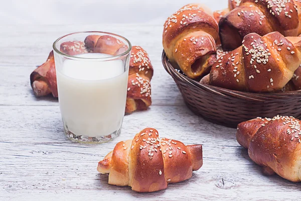 bir bardak süt üzerinde arka plan bulanık sepet ile simit 