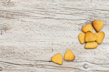 ahşap arka plan üzerinde bir kalp şeklinde kurabiye