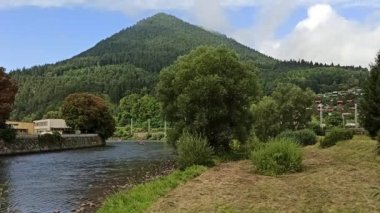 Slovakya, Ruzomberok 'taki Vah nehrinde rafting. Arka planda tren geçiyor.