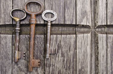 Vintage anahtarları eski ahşap zemin üzerinde. Yakın çekim. Üç eski, rustik anahtar tablo