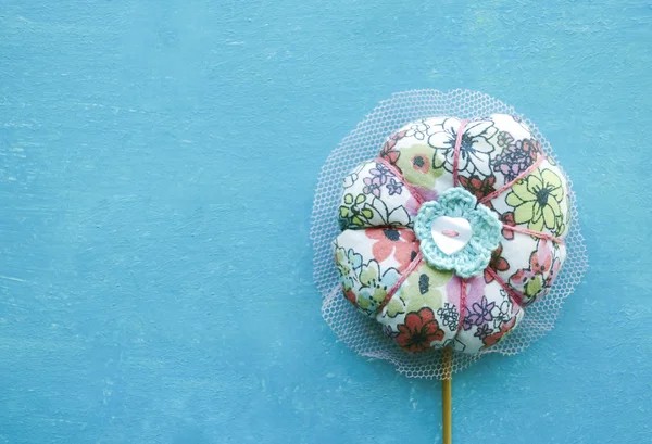 Flor textil colorida en palo. Juguete hecho a mano aislado sobre fondo turquesa — Foto de Stock